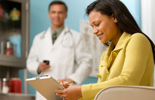 Photo of patient writing a list when meeting with her doctor